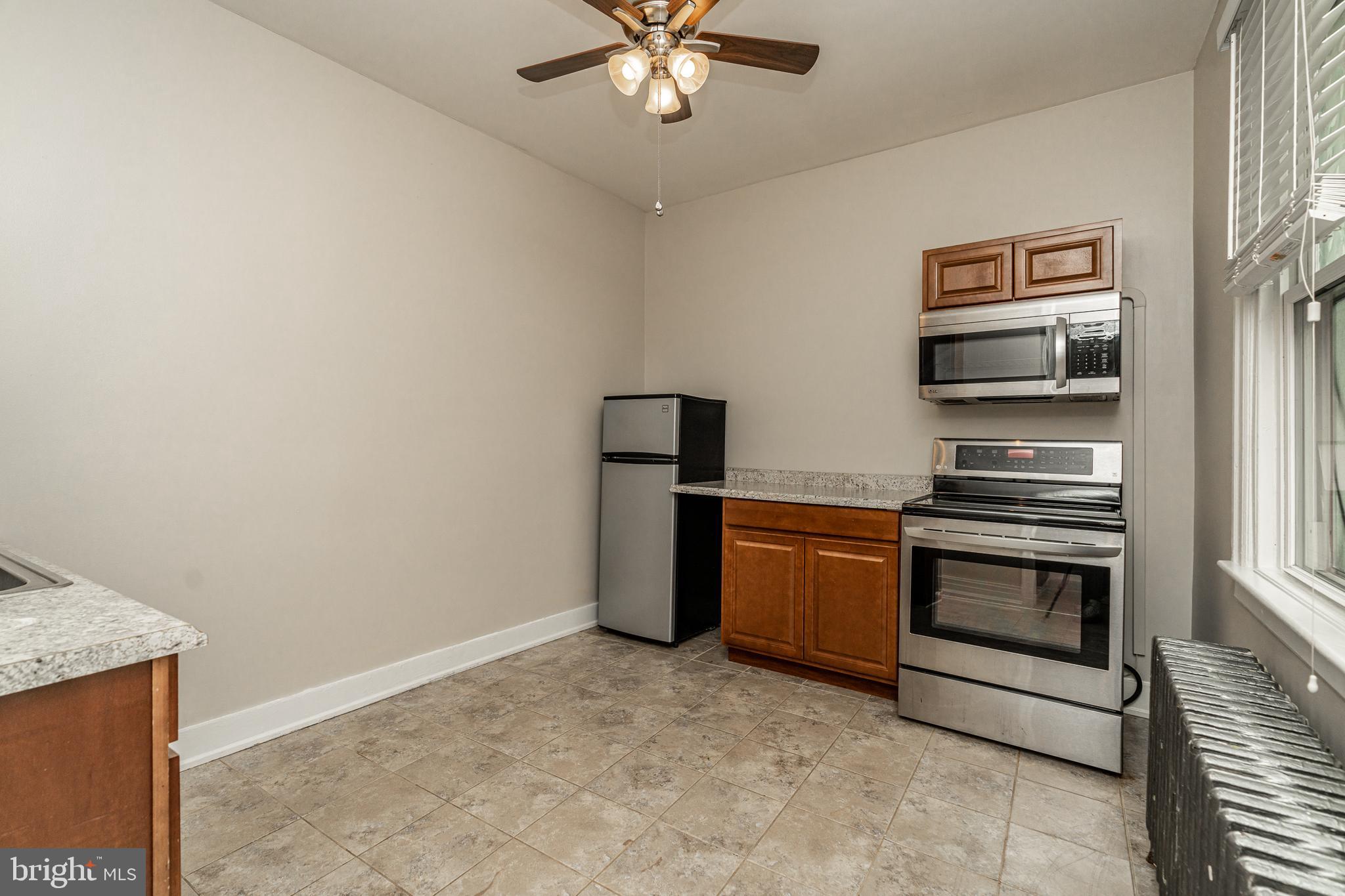 4339 Main Street, Unit R Philadelphia, PA 19127 - Photo 2 of 14 a kitchen with granite countertop a stove and a refrigerator