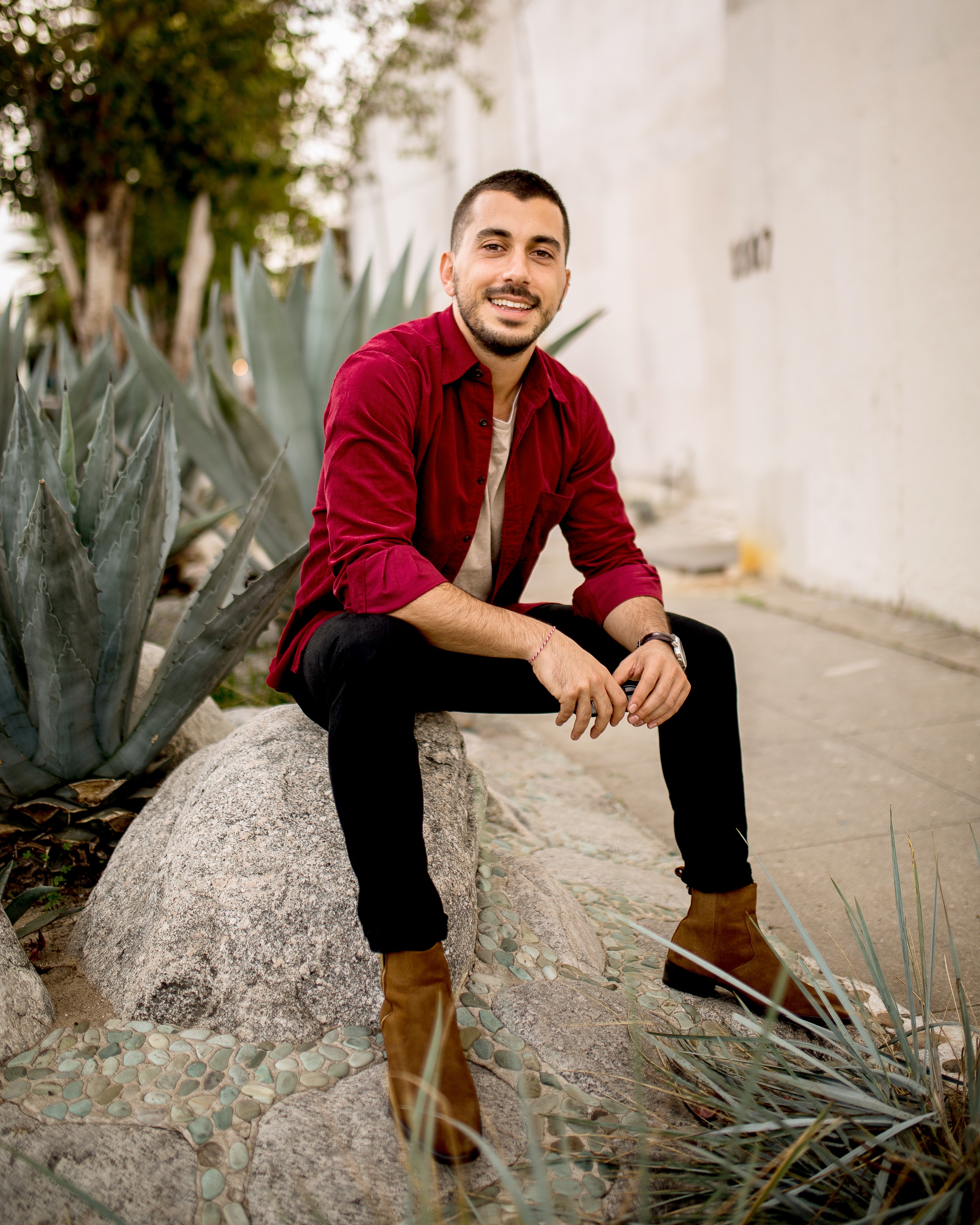 a man in a suit sitting on a rock