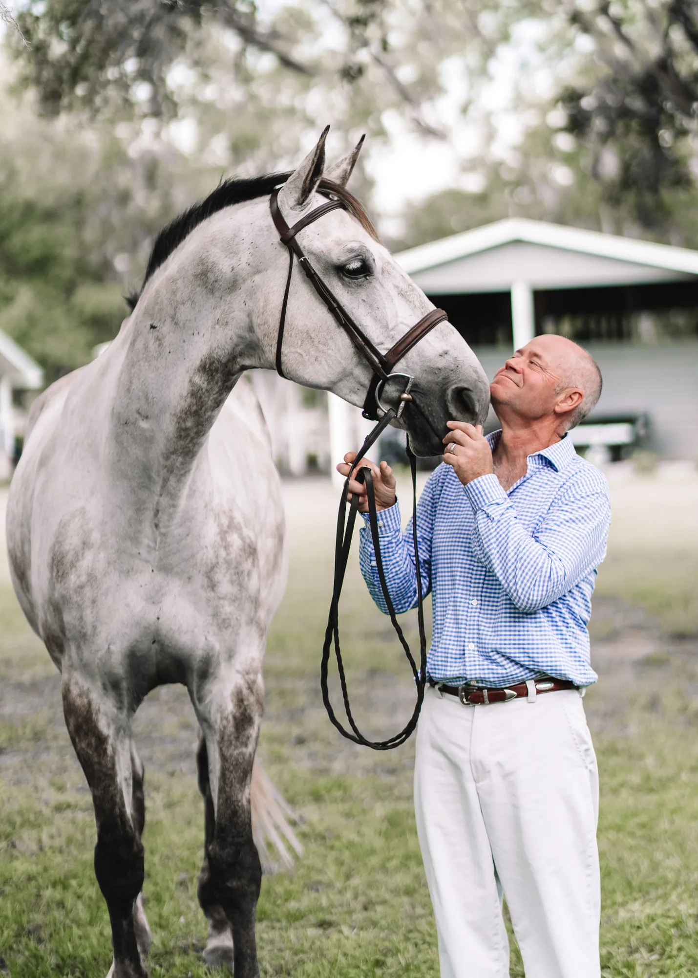 a man is standing next to a horse in a field