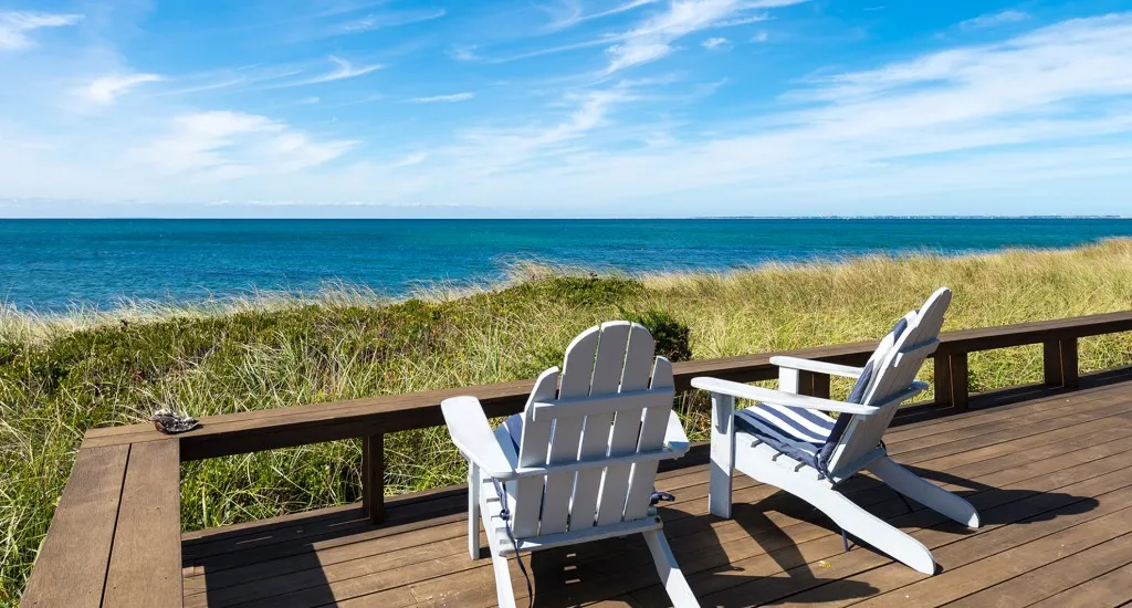 A chair on a wooden deck overlooking the ocean