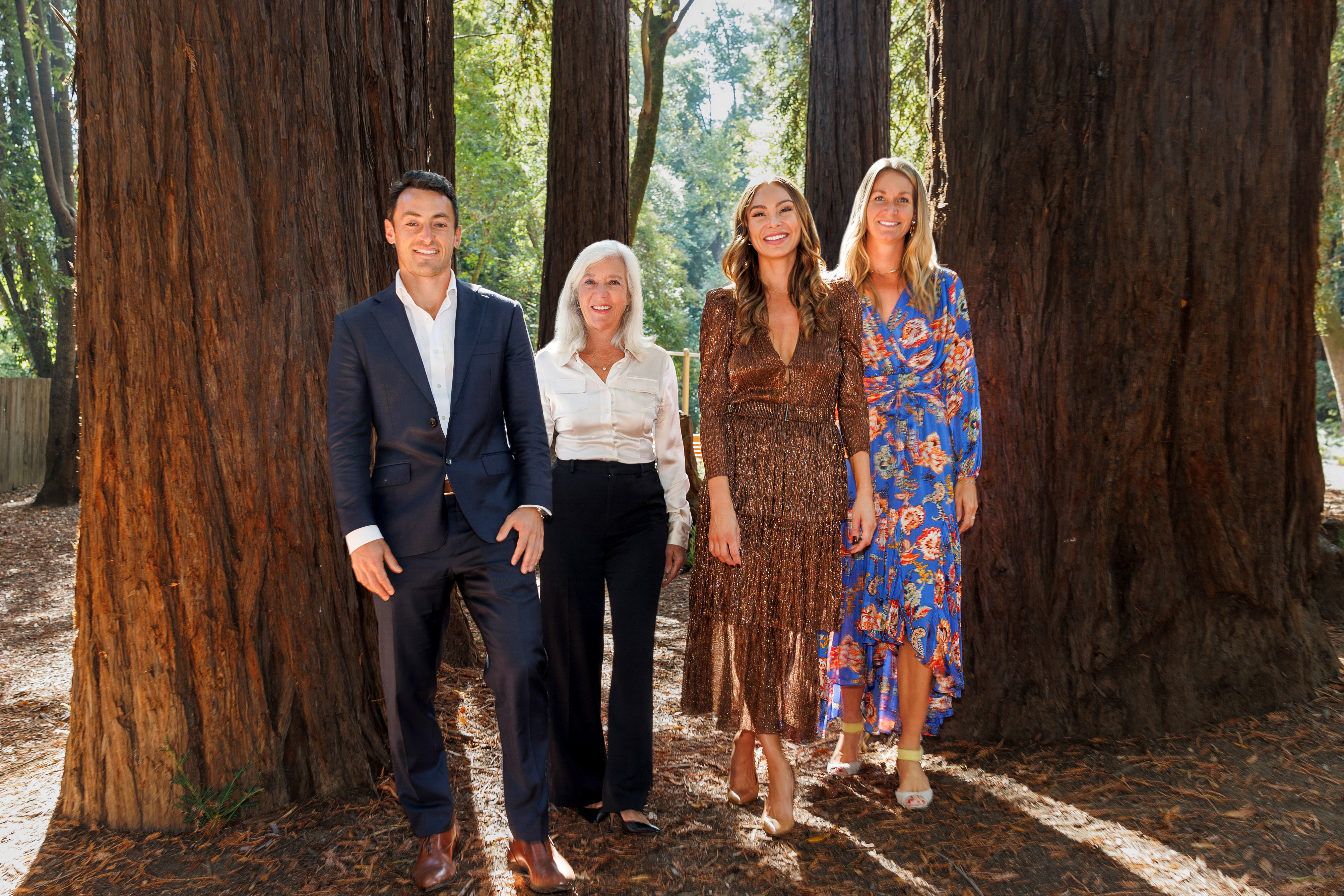 Professional real estate team standing confidently amidst towering redwood trees, embodying The Key to Your Dreams® in Marin County.