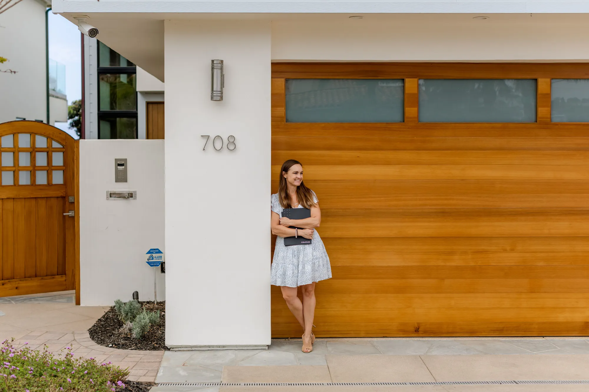 A woman standing on a sidewalk with a cell phone.
