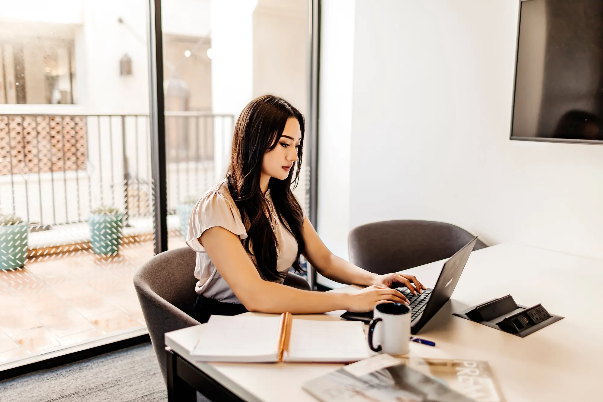 A woman sitting at a desk using a laptop