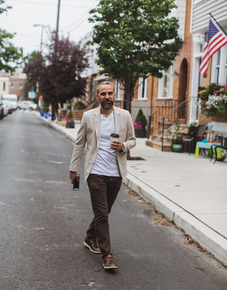 a man walking down the street with a skateboard