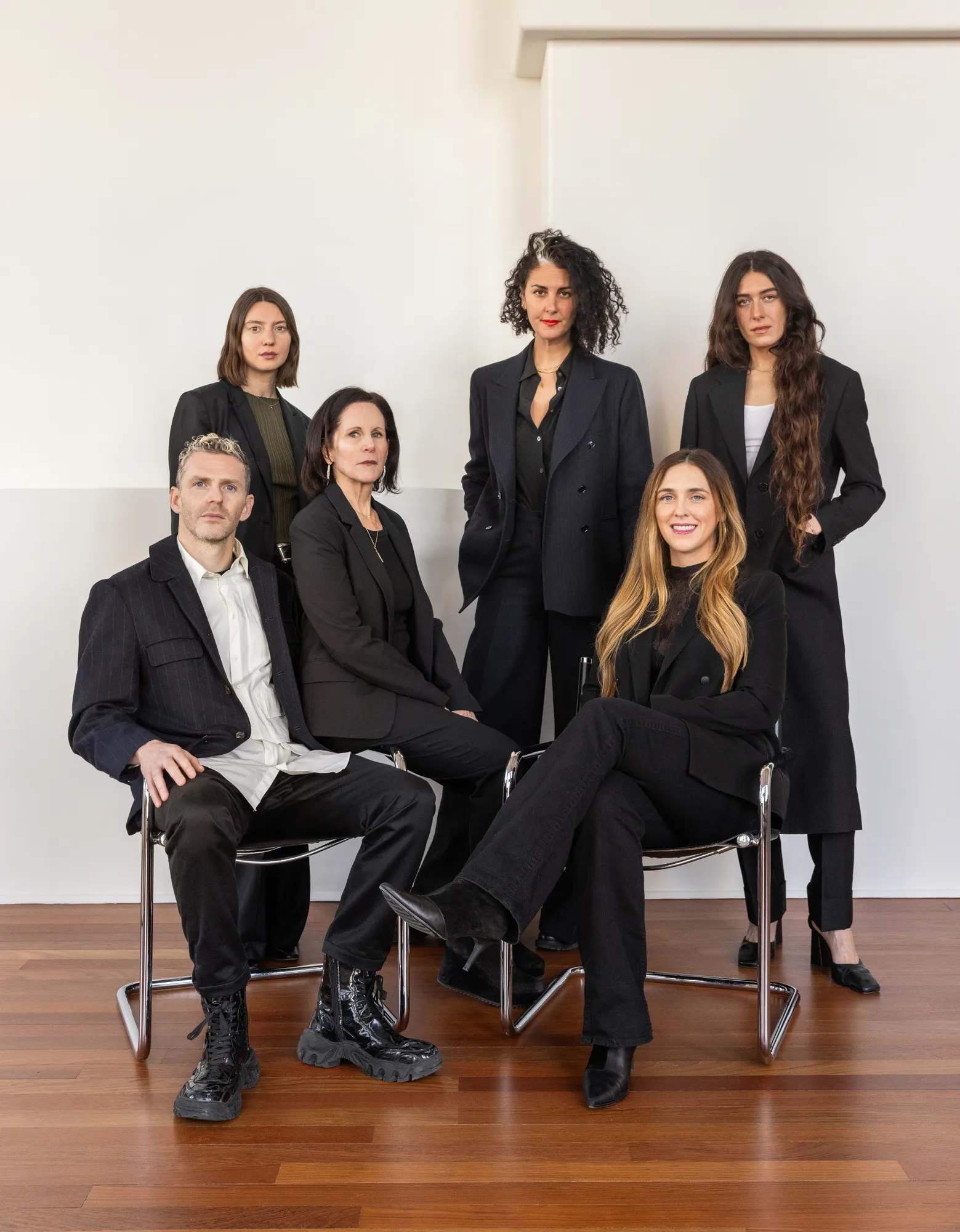 TWWL team dressed in black standing against a white wall