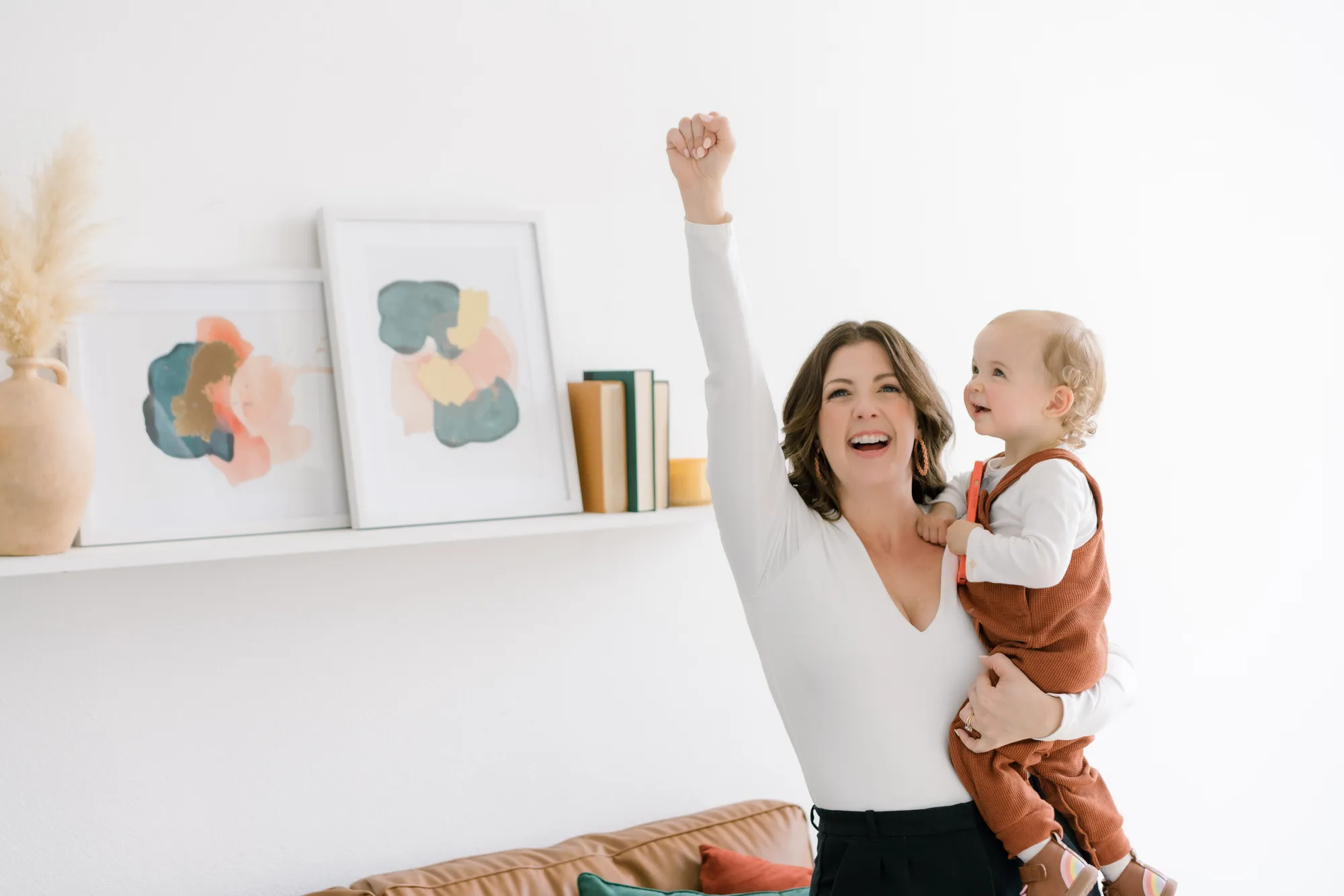 A woman holding a baby in a room.