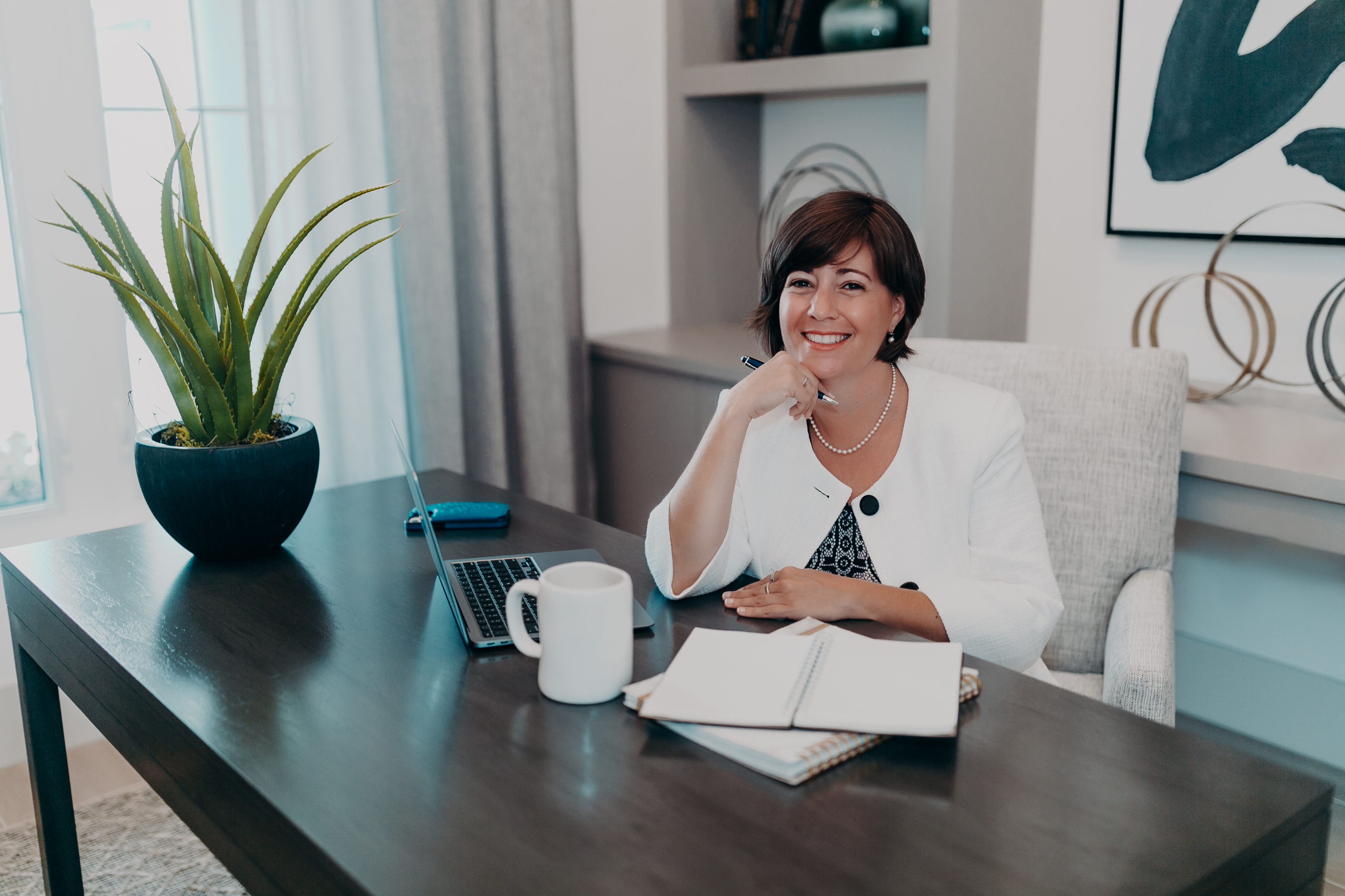 A woman sitting at a table with a coffee cup