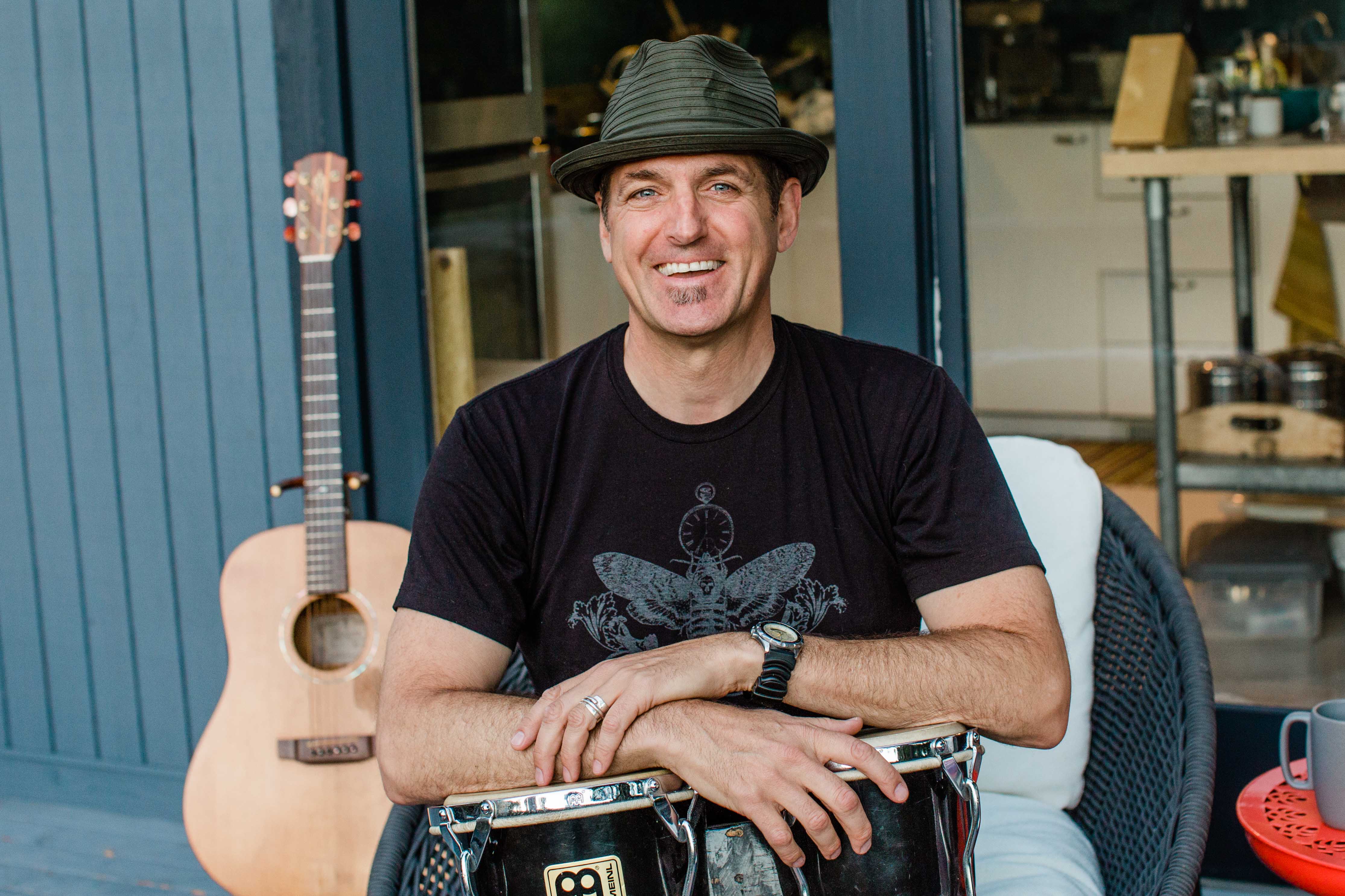 A man in a bandana holding a guitar