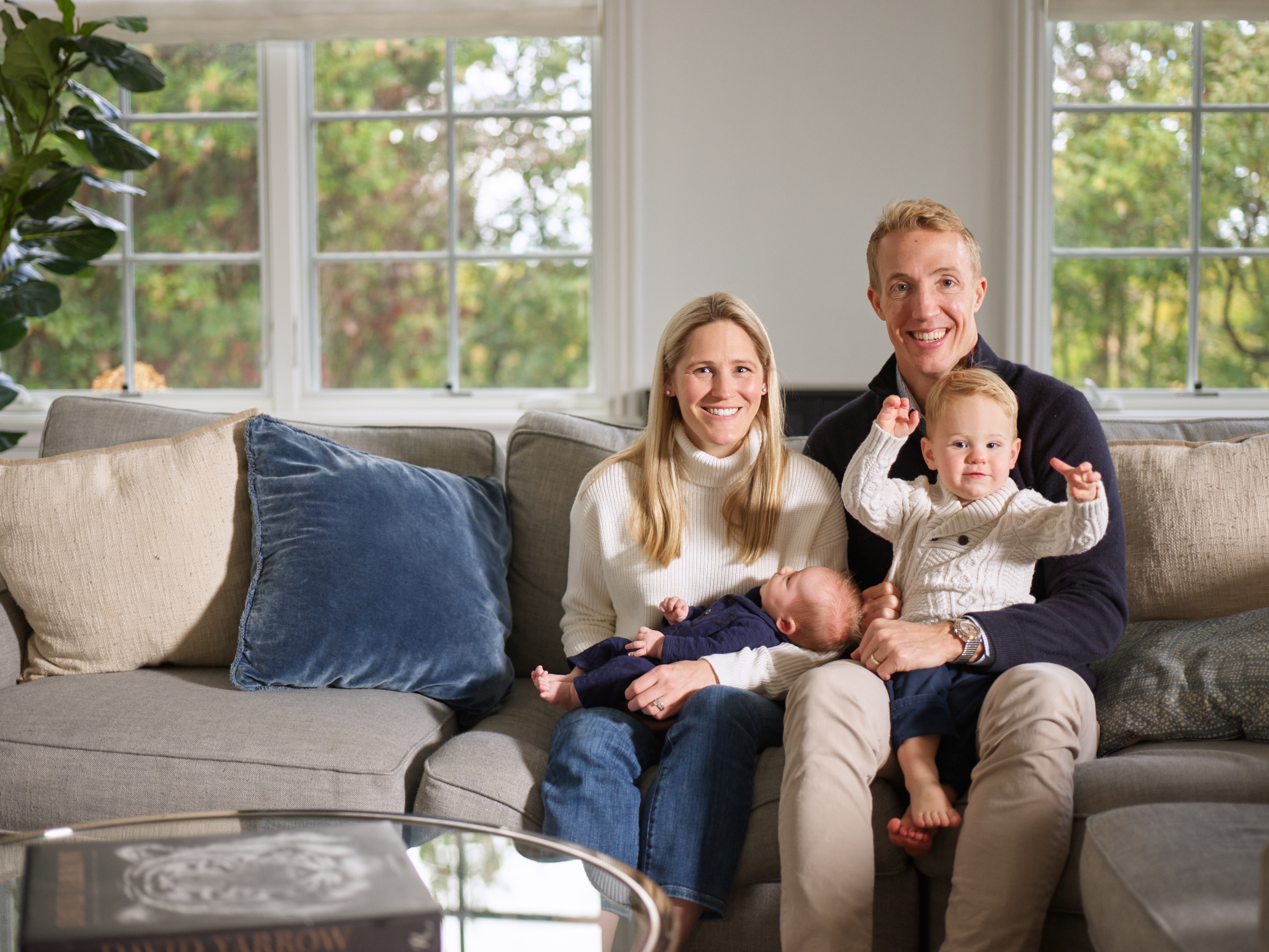 a family sitting on a couch with a dog