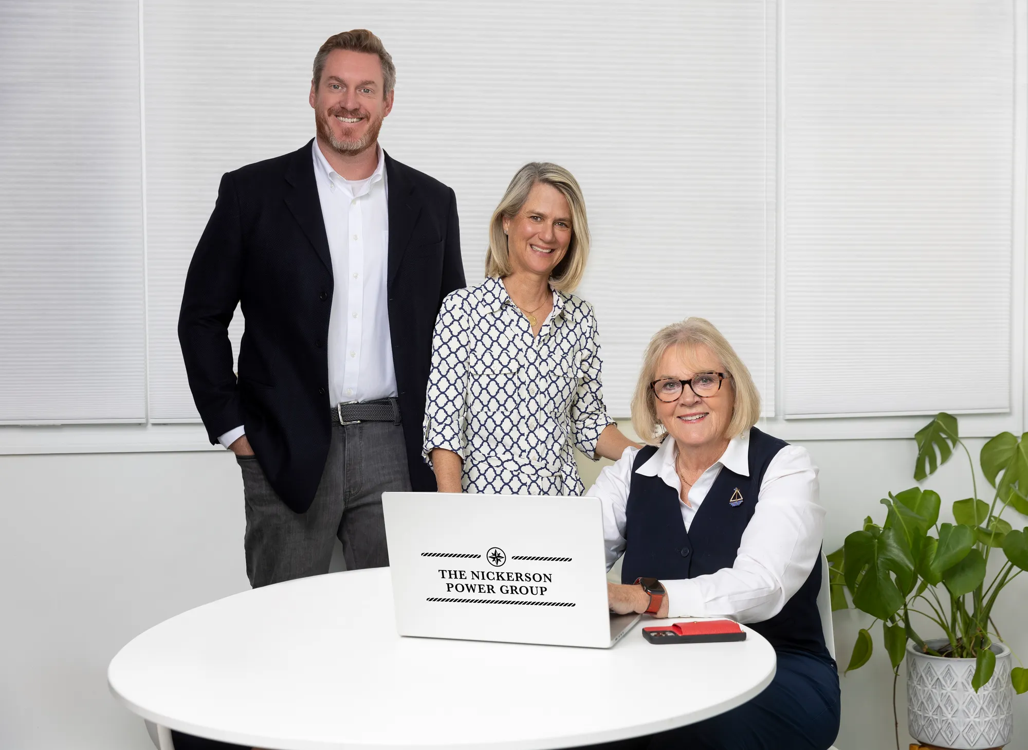 Image of one man and two women standing at a table