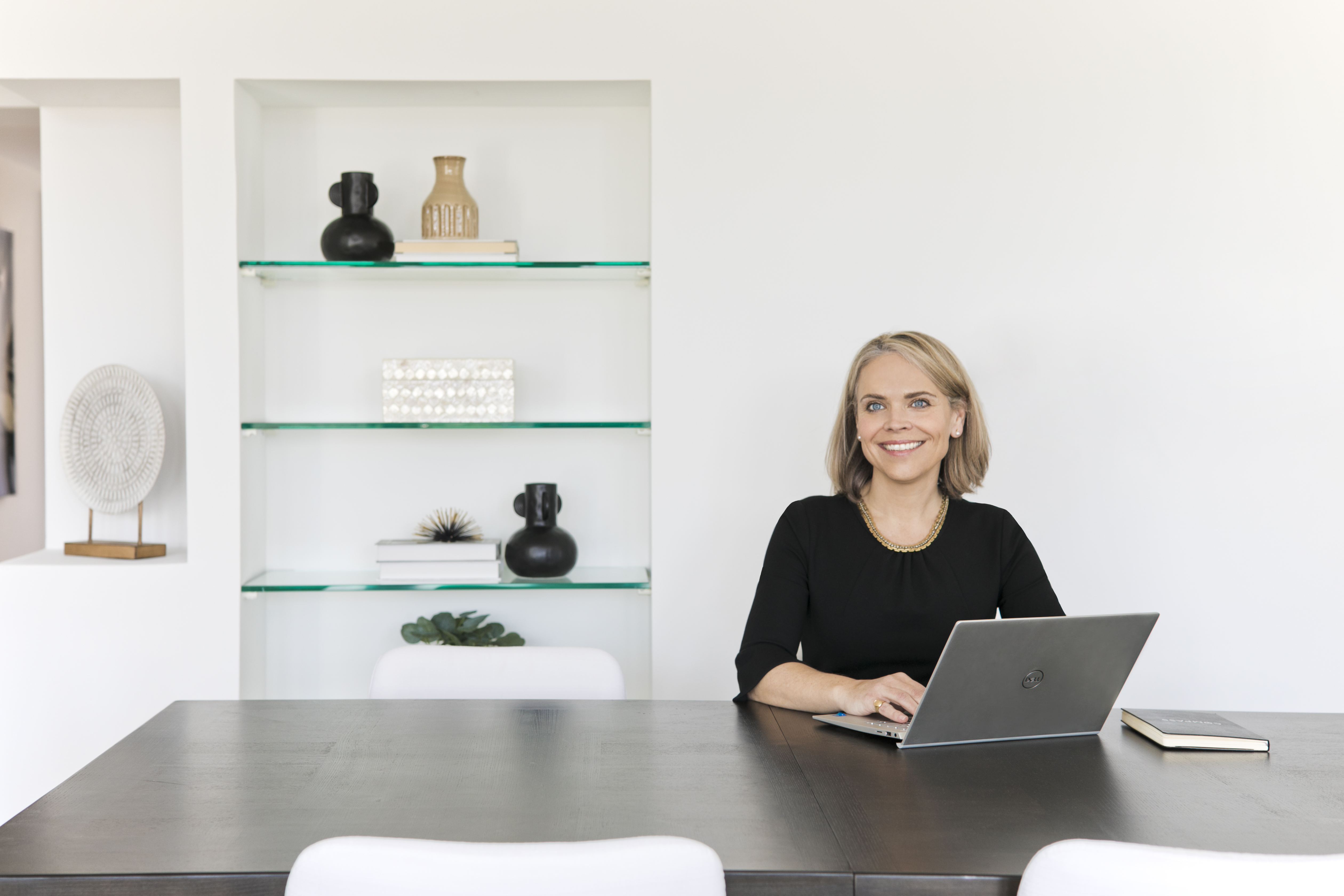 A woman sitting at a table with a laptop.