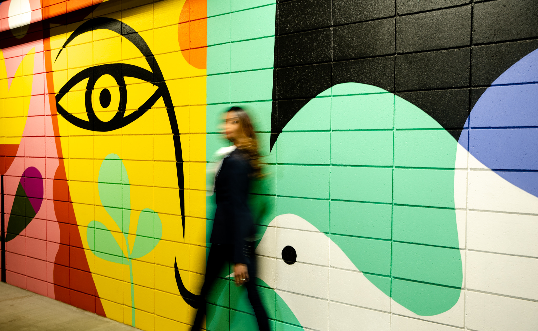 A woman standing next to a wall with graffiti on it