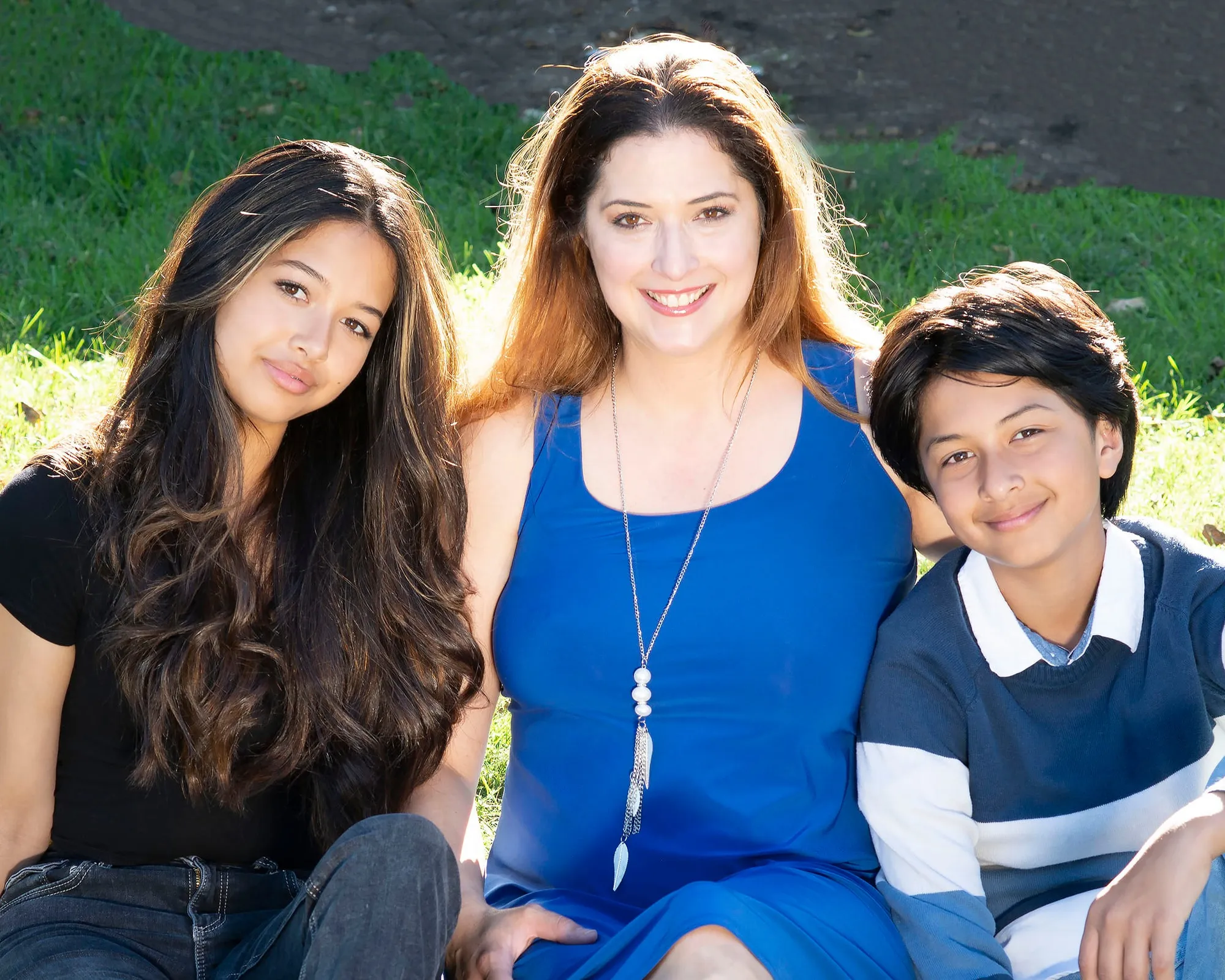 a group of people sitting on a grassy area