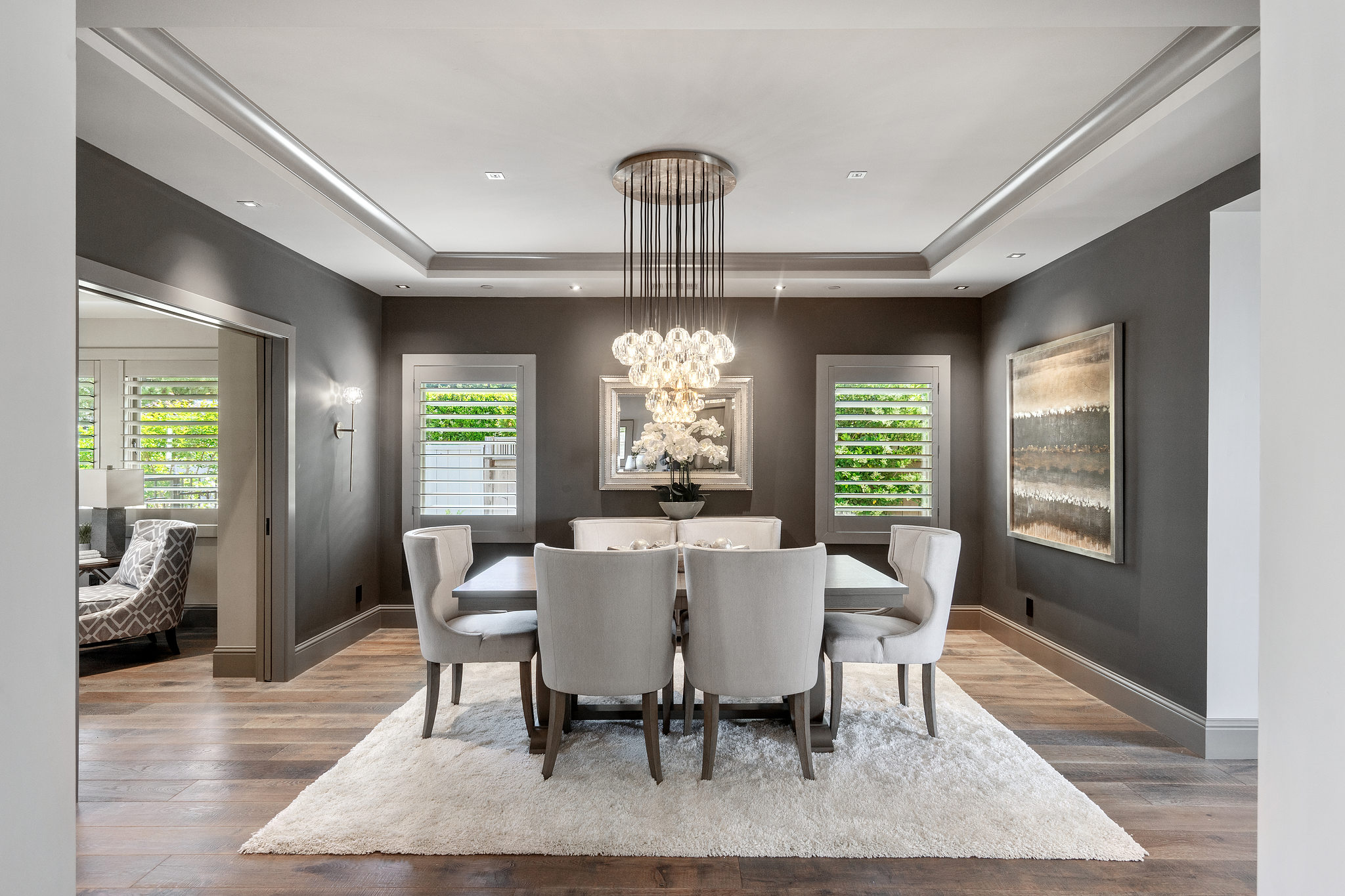 A living room with a large window and a dining room table