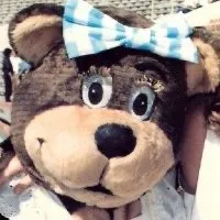 The logo of a teddy bear wearing a red bow tie.