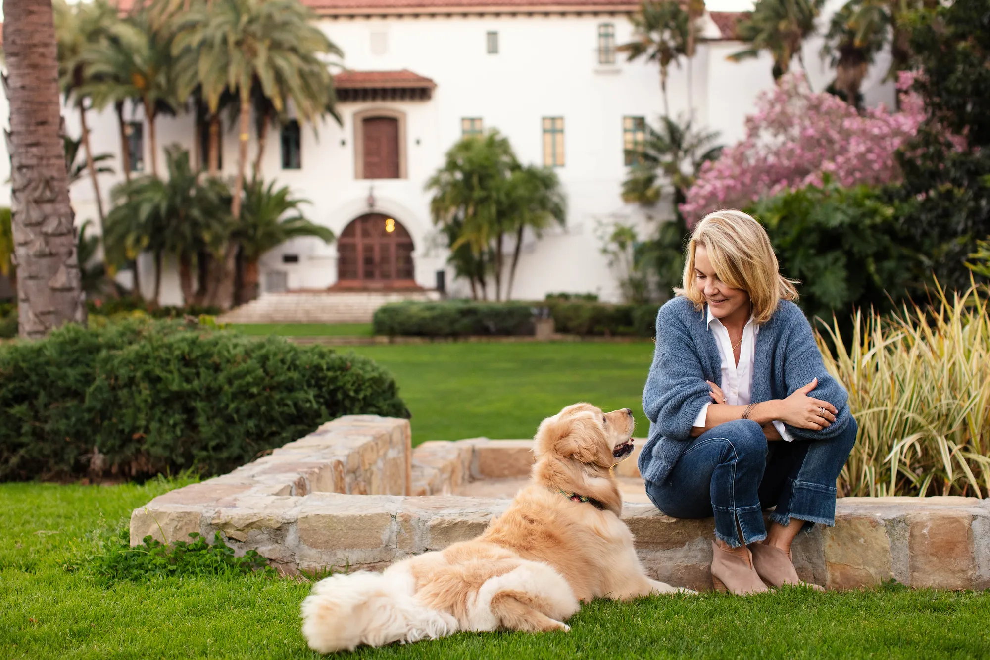 A woman sitting on the grass with a dog