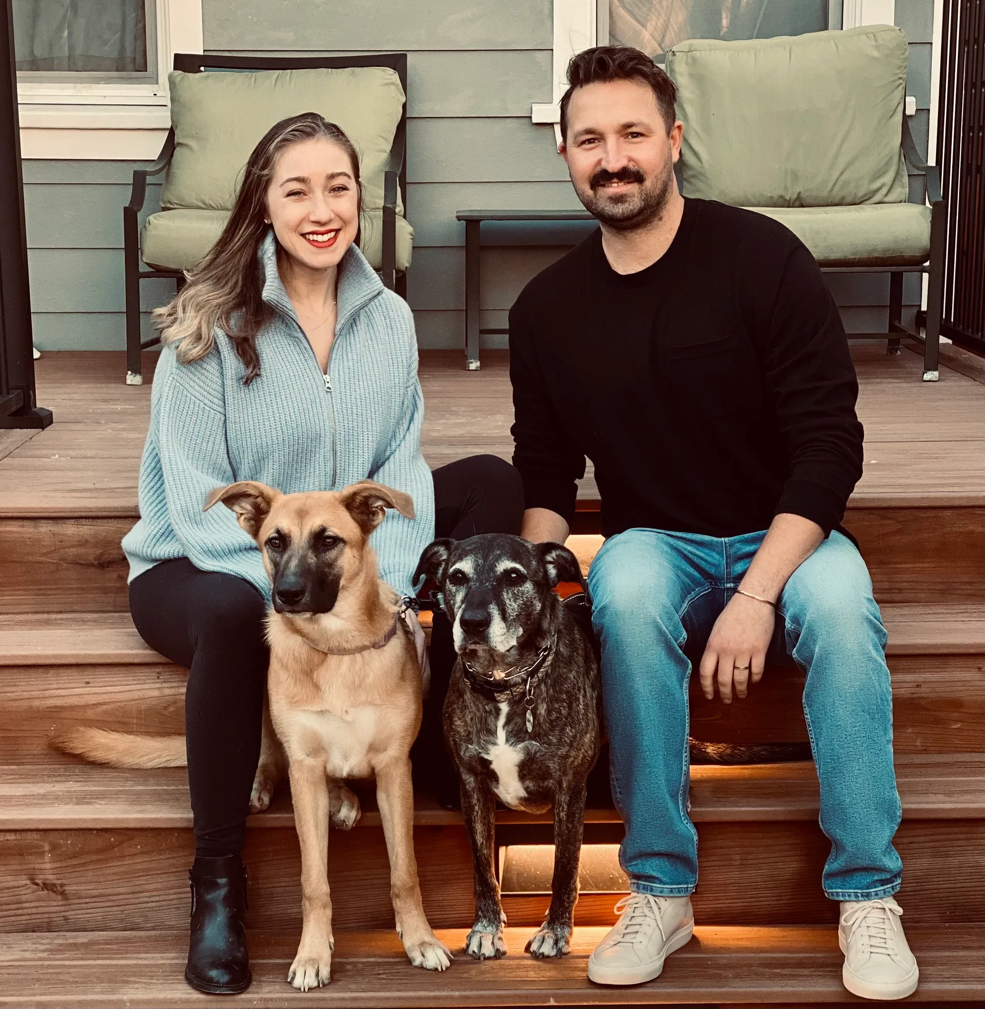 A man and woman sitting on a bench with a dog.
