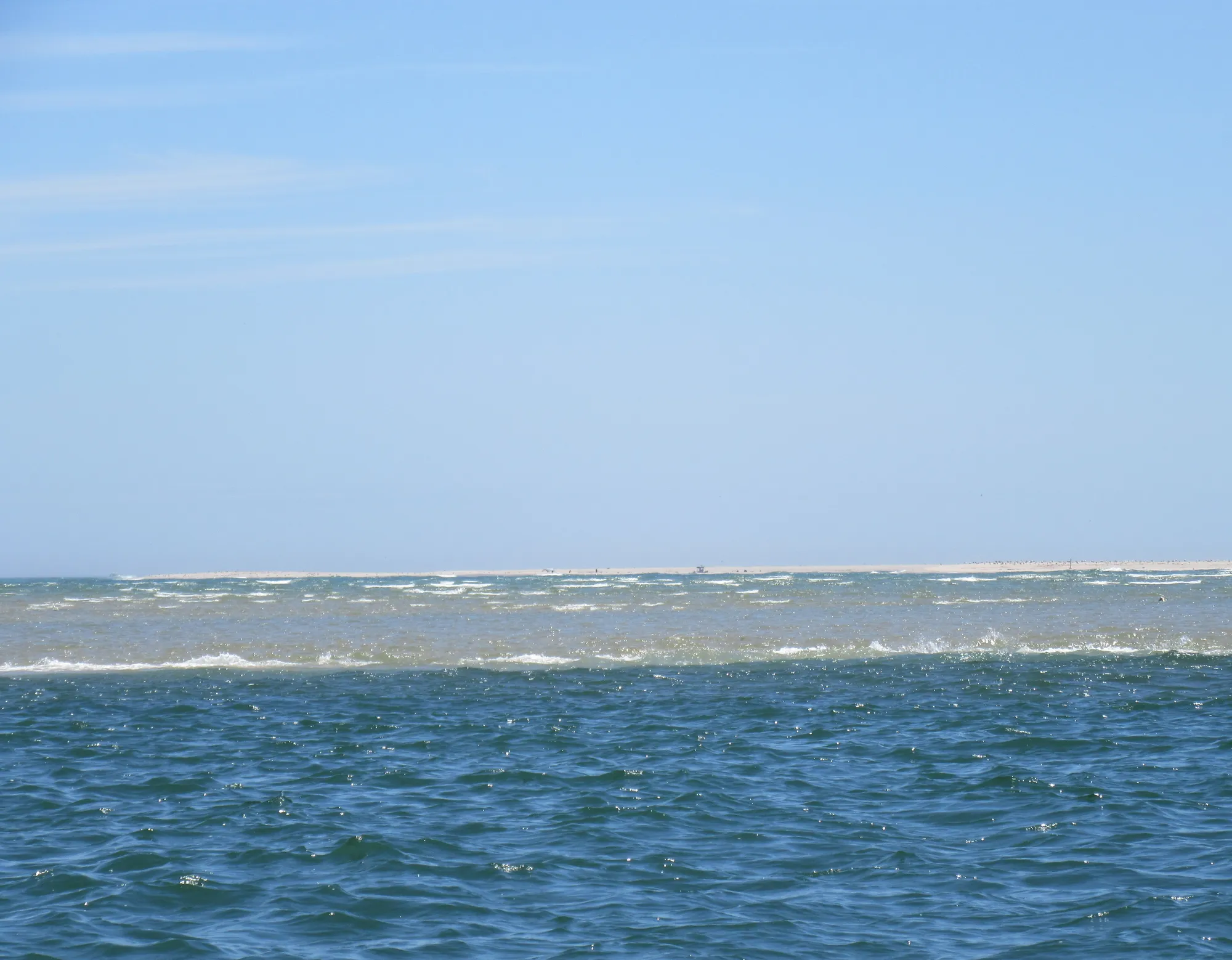 A large body of water with a sail