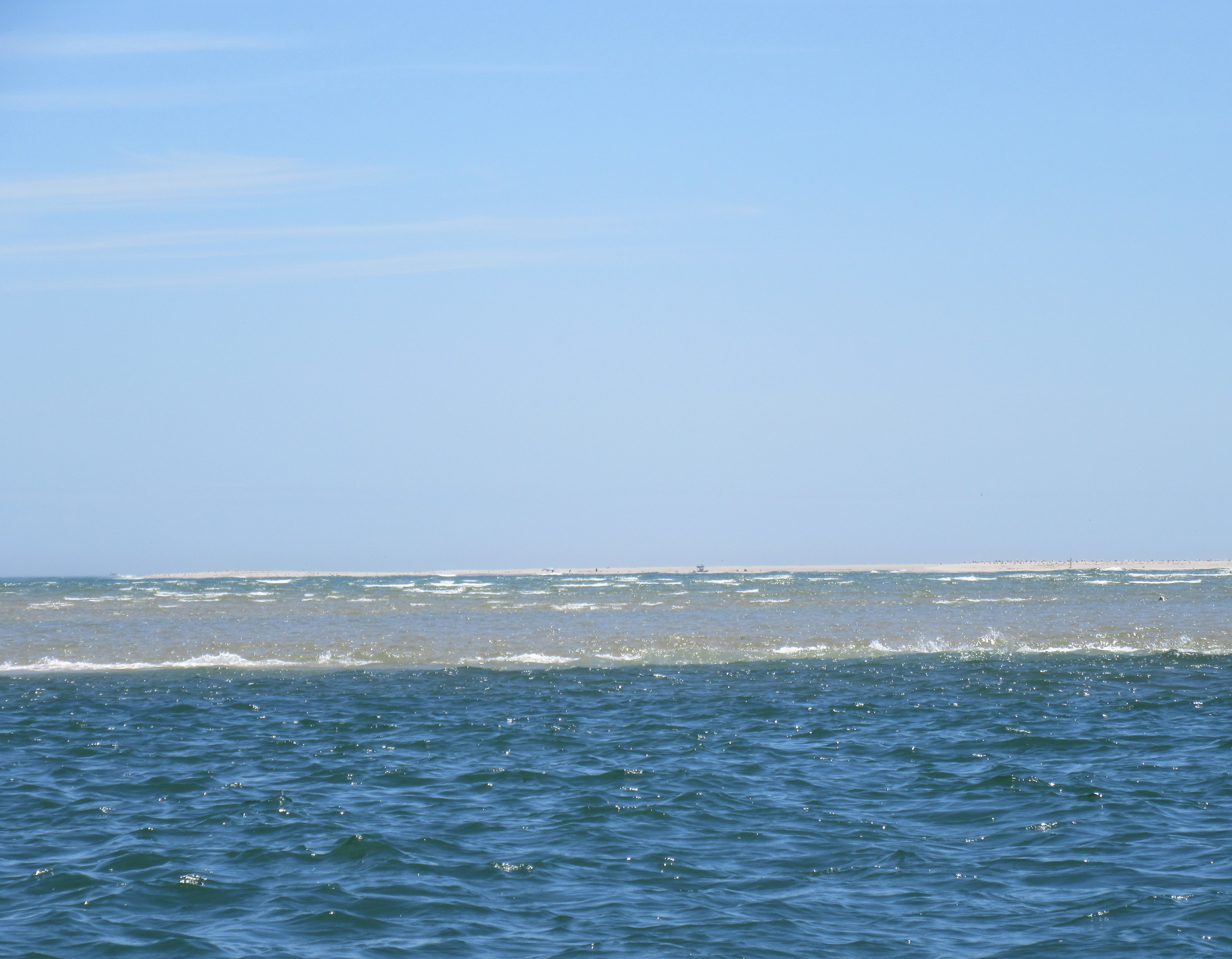 A large body of water with a sail