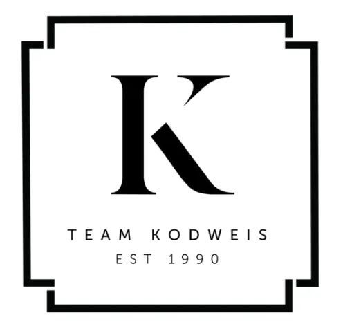 Kodweis Team logo. A capital K in a classic serif font, with the words "team Kodweis, established 1990" underneath.