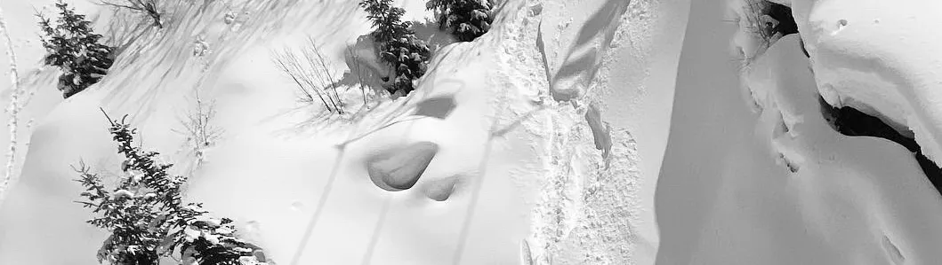 A person standing in the snow with a pair of scissors