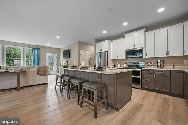 a kitchen with kitchen island granite countertop wooden floors and wooden cabinets