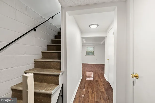 a view of a hallway with wooden floor and entryway