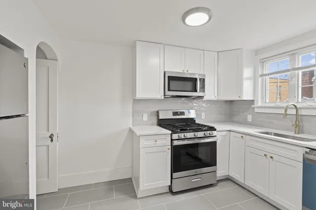 a kitchen with white cabinets and stainless steel appliances