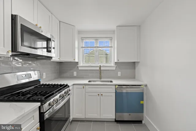 a kitchen with stainless steel appliances a sink stove and microwave