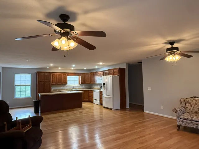 a view of a kitchen with a stove wooden floor and chandelier