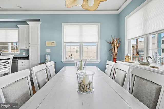 a view of a dining room with furniture large windows and wooden floor
