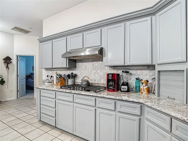 a spacious bedroom with a bed a window and a chandelier