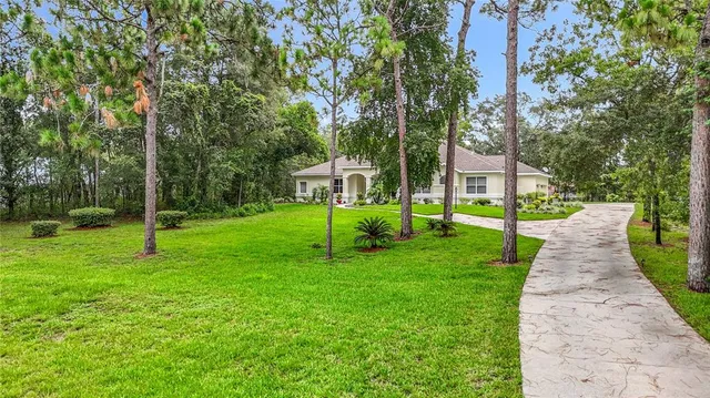 a kitchen with stainless steel appliances granite countertop a sink dishwasher a refrigerator and white cabinets