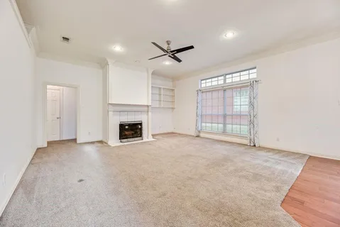 an empty room with windows and fireplace