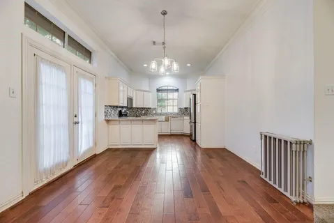 a view of kitchen with refrigerator and white cabinets