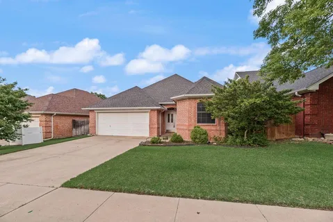 a front view of a house with a garden and yard