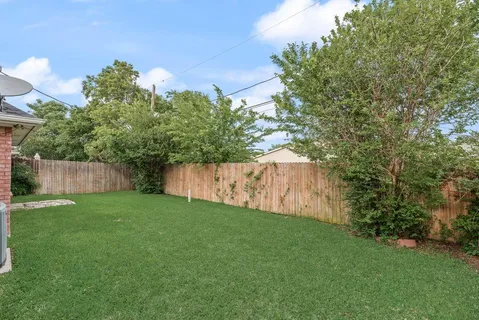 a front view of house with yard and trees in the background