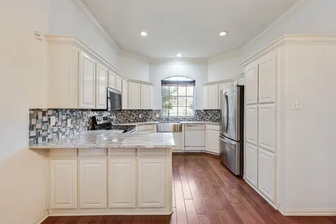 a kitchen with kitchen island white cabinets and refrigerator