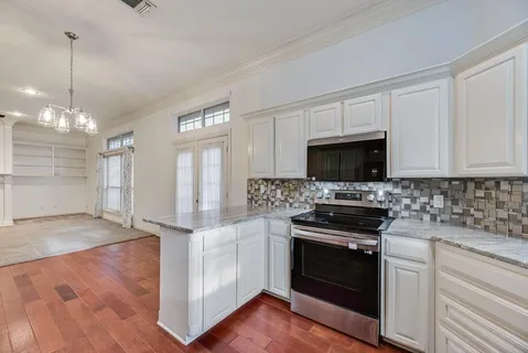 a kitchen with granite countertop a stove and a sink
