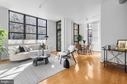 a living room with furniture and a table with wooden floor