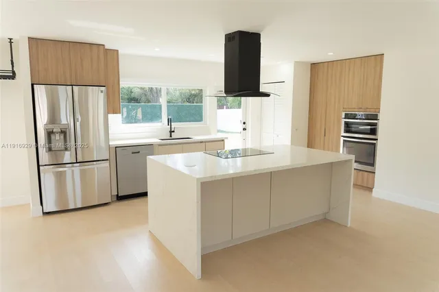 a kitchen with appliances a sink and a refrigerator