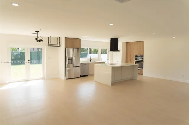 a view of a kitchen with furniture and an empty room