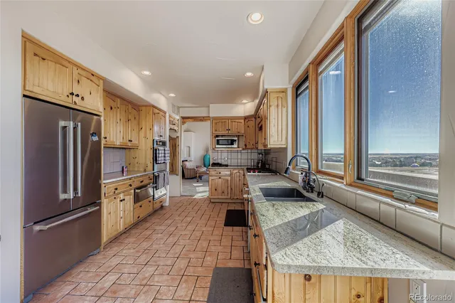 a kitchen with stainless steel appliances granite countertop a refrigerator and a stove