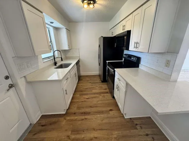 a kitchen with sink a microwave and refrigerator
