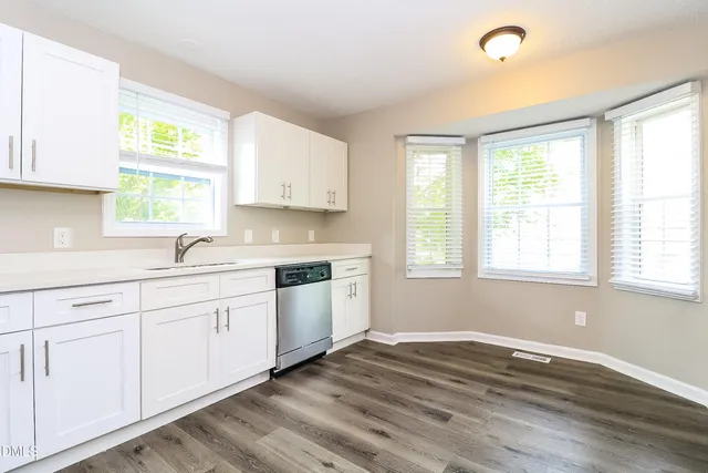 a kitchen with granite countertop white cabinets and white appliances