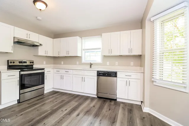 a kitchen with granite countertop white cabinets and white appliances