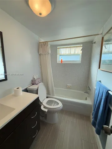 a bathroom with a sink a toilet a tub and a mirror