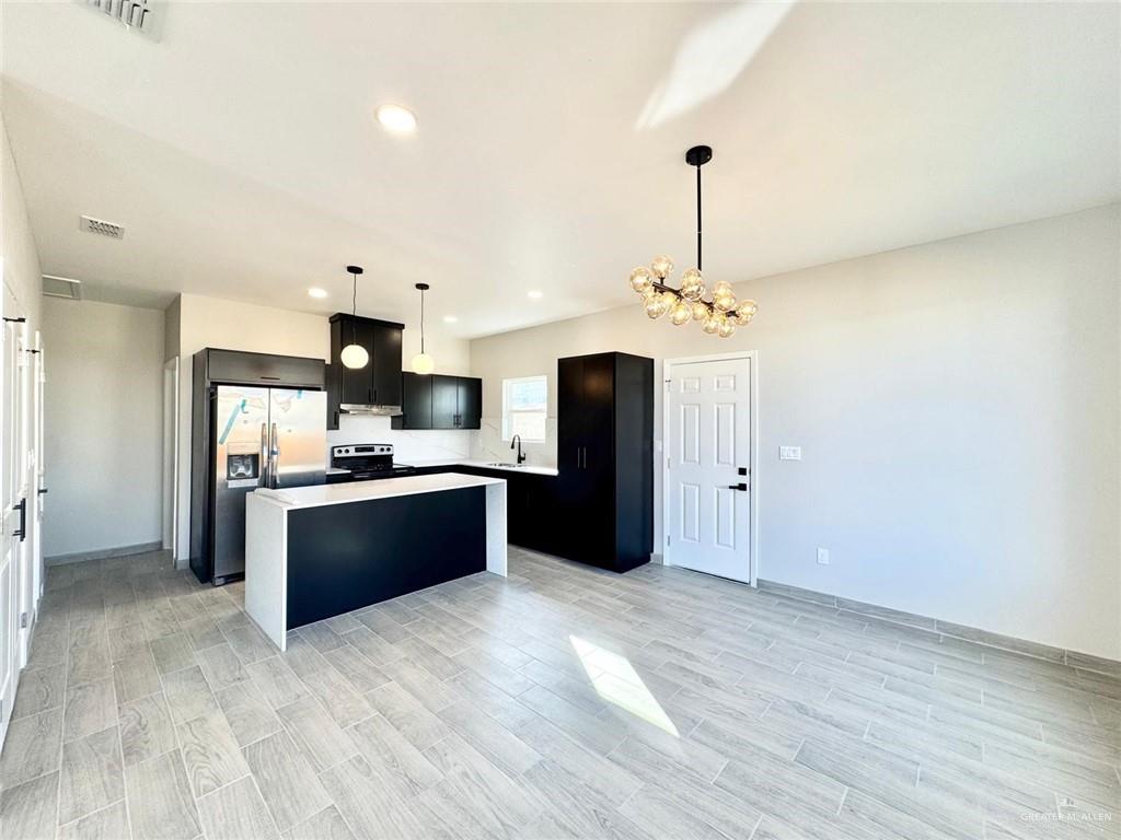 2103 Selena Street, Unit 4 Mission, TX 78572 - Photo 5 of 15 a kitchen with kitchen island stainless steel appliances a stove top oven and refrigerator