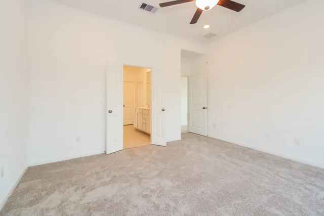 an empty room with closet and fan