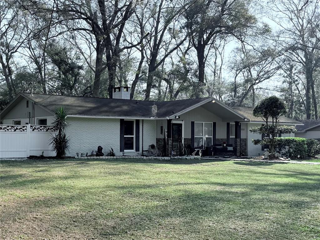 7713 Southwest 8th Avenue Gainesville, FL 32607 - Photo 1 of 32 a front view of house with yard and green space